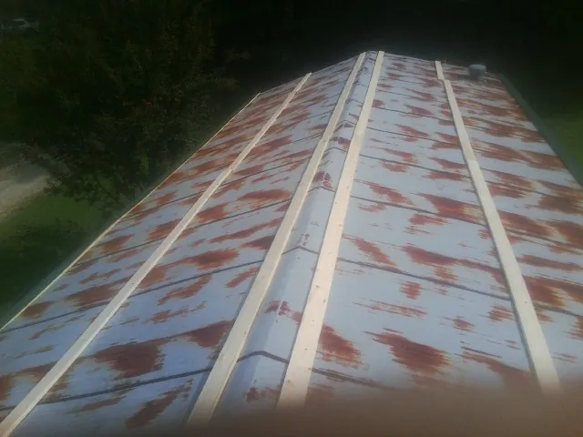 Rusted metal roof panels with new wood purlins before replacement — Storm Damage Roof Repair in Plant City by Roofing Brothers